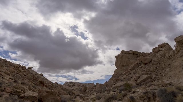 Thick clouds drift over rocky canyon, Time Lapse