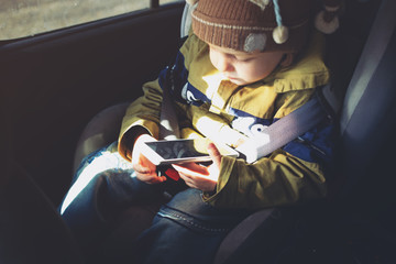 kid with phone in the car