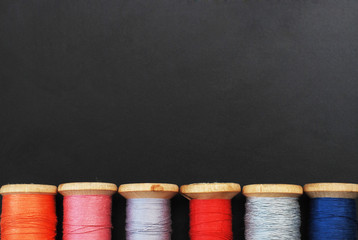 Close up Rolls of Vintage Colorful Threads. Clothes Repair, Black Dark Background. Sewing work process. copy Space.