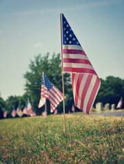 American flags displayed at a cemetery on Memorial Day. Vintage tone.