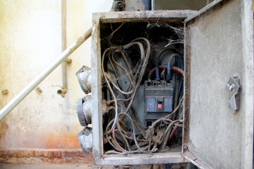 Old electric wire and switch in dirty service box on vintage background