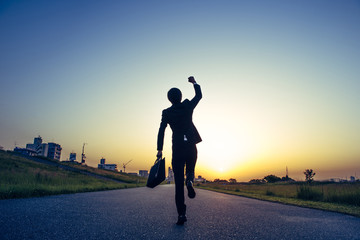 朝日にむかってジャンプするビジネスマン