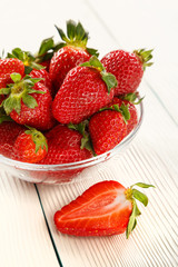 Ripe strawberry on a white wooden background