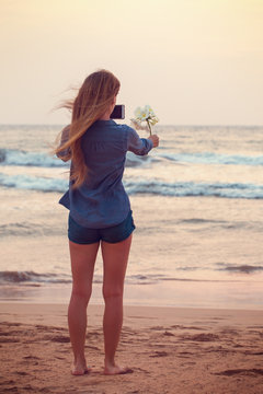 Girl takes pictures of Plumeria flower