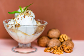 Vanilla ice cream in bowl and walnuts