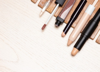 Different types of make-up concealers on white wooden table