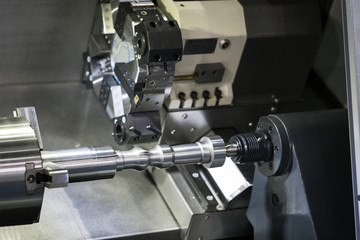 Operator machining automotive part by cnc turning machine,