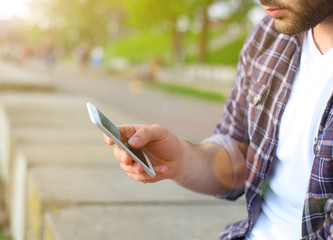 Man using his mobile phone outdoor, close up.