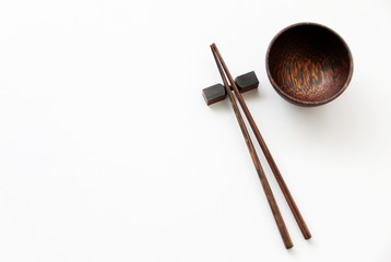 old wood chopsticks and wood bowl on White table background.Flat lay,Copy space