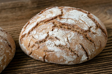 Delicious baked bread on a wooden background