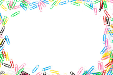 Colored paper clips spread on border with center copyspace isolated on a white background.