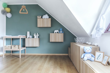 Stylish scandinavian newborn baby room with toys, teddy bear, mock up photo frame. Modern green...