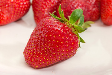 Garden strawberry closeup against of other berries at selective focus