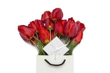 Beautiful red tulips in a paper gift bag, gift and on a white background. Top View.