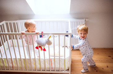 Two toddler children in bedroom at home.
