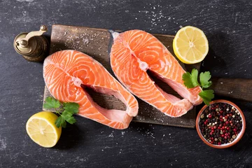  fresh salmon steaks with ingredients for cooking, top view © Nitr