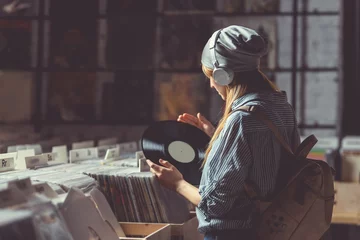 Fototapete Musikladen Junges Mädchen, das Musik über Kopfhörer hört