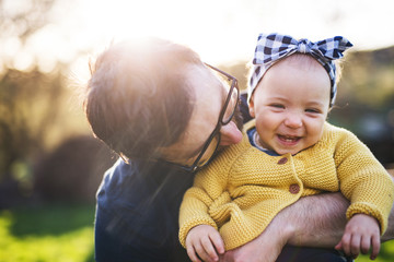 A father with his toddler daughter outside in spring nature. - Powered by Adobe