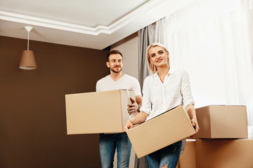 Fototapeta na wymiar Moving House. Man And Woman Holding Boxes