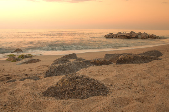 Tramonto sul mar Jonio. Rocce su spiaggia in primo piano. Mare calabria, soverato, italia