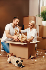 Couple With Dog And Boxes Moving In New Apartment