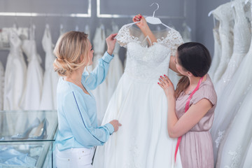 A young seller and customer with a wedding dress