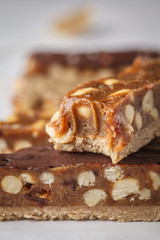 Vegan raw homemade chocolate candy snickers bars. Healthy lifestyle and raw vegan food concept.