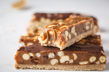 Homemade raw vegan chocolate candy snickers bars. Healthy lifestyle and raw vegan food concept.