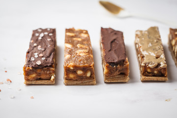 Various of raw vegan homemade chocolate candy snickers bars. Healthy lifestyle and raw vegan food concept.