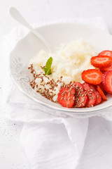Rice milk porridge with strawberry and flax seeds for breakfast. White background, top view, copy space.