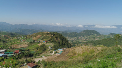 Aerial view of rice terraces and agricultural farm land on the slopes of mountains valley. Cultivation of agricultural products in mountain province. Mountains covered forest, trees. Cordillera region