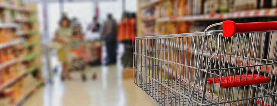 Shopping Trolley, Empty, With Red Handle On Blur Supermarket Background. 3d Illustration