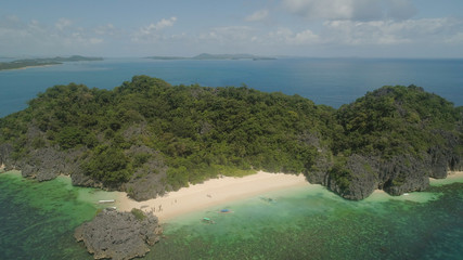 Aerial view Matukad island with sand beach and turquoise water in blue lagoon among coral reefs, Caramoan Islands, Philippines. Landscape with sea, tropical beach. © Alex Traveler