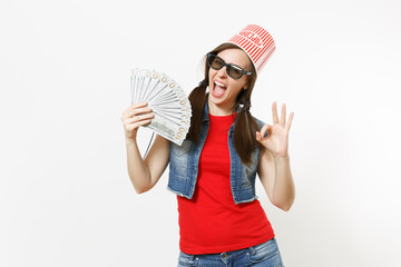 Young overjoyed pretty woman in 3d glasses with bucket for popcorn on head watching movie film,...