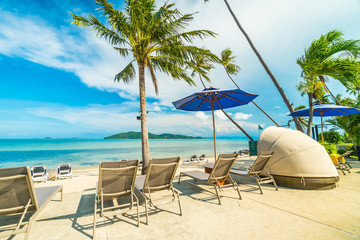 Beautiful tropical beach and sea with coconut palm tree and umbrella and chair in paradise island