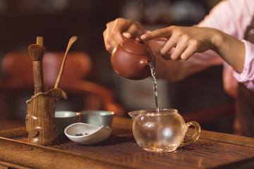 Fototapeta na wymiar Young woman pouring tea