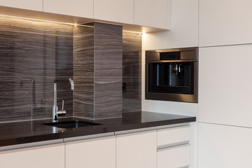 New modern kitchen with built in oven and chrome water tap. LED worktop illumination