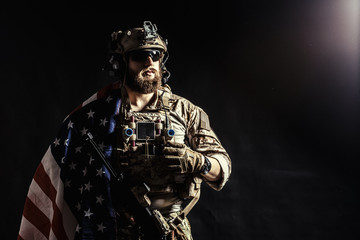 Soldier holding machine gun with national flag