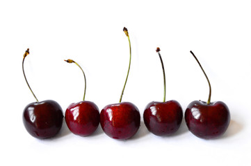 Berries cherries lie in a row on a white background