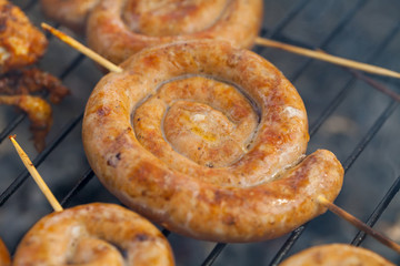 Spiral pork sausage on barbeque grill