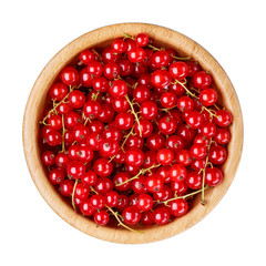 Red currant berries in wooden bowl isolated on white background. Top view.