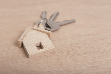 Key home on wood table background.