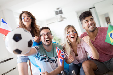Young group of friends watching sport on television