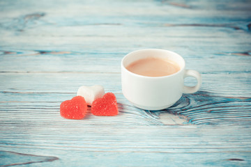 Cup of coffee with macarons on a blue wooden background. Selective focus.