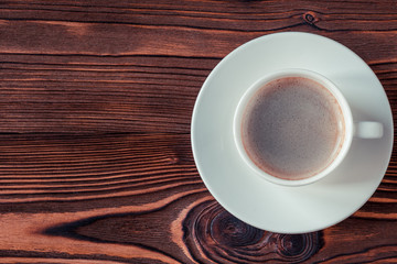 Cup of coffee on a wooden background. Copy space. Selective focus.