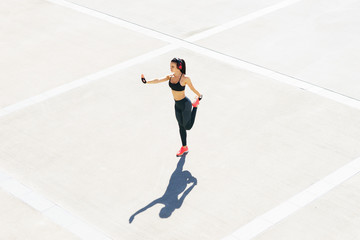 Young, fit and sporty girl in the street. Fitness, sport, urban jogging and healthy lifestyle concept.