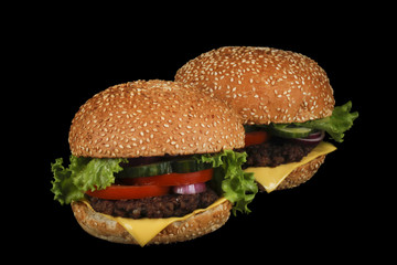 two burgers isolated on black background