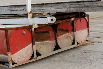 Volgograd, Russia. Four empty rusty red barrels. Details of the old wooden pontoon bridge. The sign...