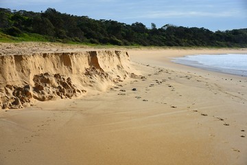 Storm beach erosion on sand background