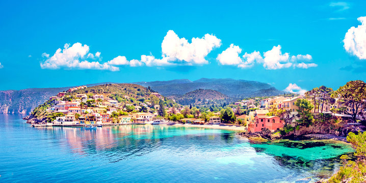Beautiful landscape with bay and colorful buildings on the background of picturesque clouds in the town of Asos, Greece, Kefalonia. Wonderful exciting places. Panorama.